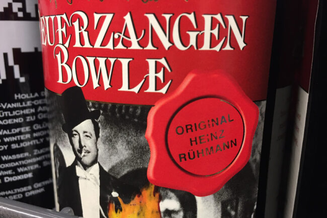 Ettikett einer Glühweinflasche mit einem Foto von Heinz Rühmann. Auf einem Siegel steht: "Original Heinz Rühmann"