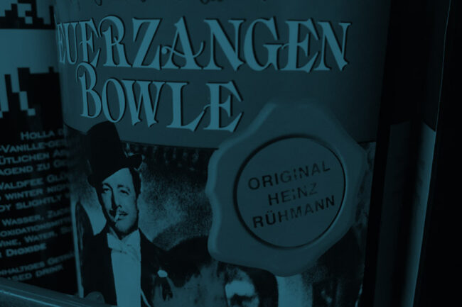 Ettikett einer Glühweinflasche mit einem Foto von Heinz Rühmann. Auf einem Siegel steht: "Original Heinz Rühmann"