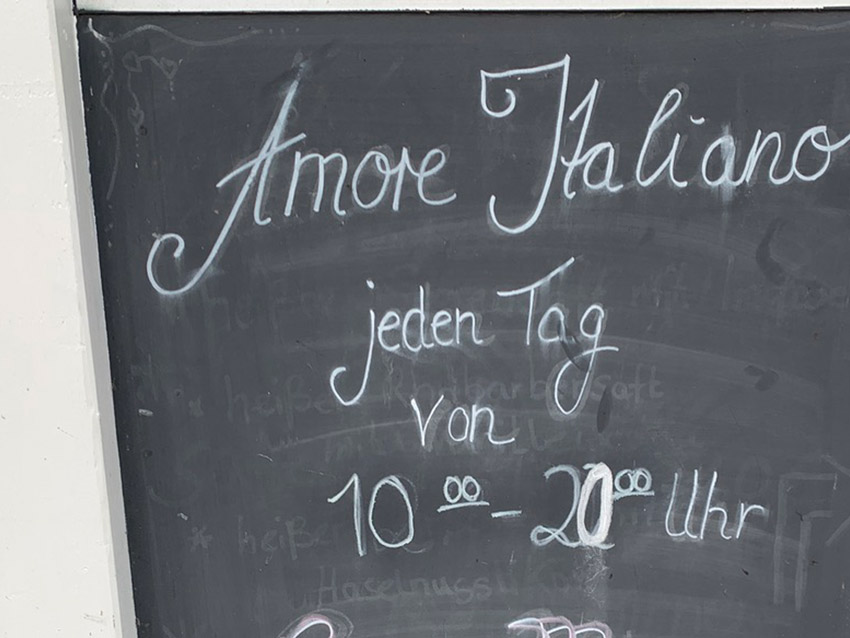 Tafel mit der Kreide-Aufschrift: "Amore Italiano jeden Tag von 10 - 20 uhr.