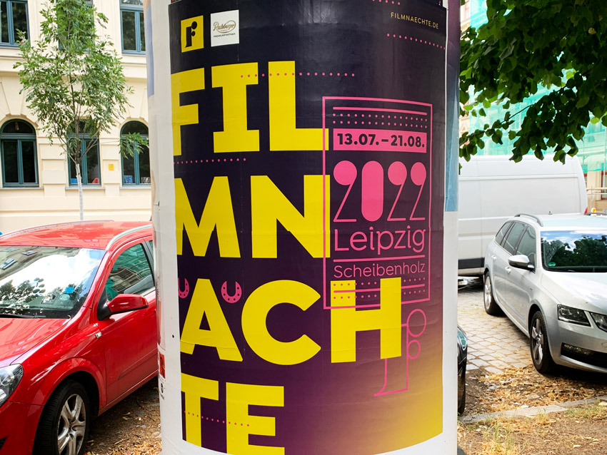 Litfasssäule mit Plakat. Der Text "Fimnächte" ist sinnlos umgebrochen und dadurch nicht leesabar.