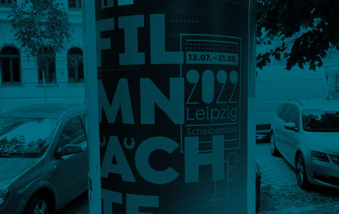 Litfasssäule mit Plakat. Der Text "Fimnächte" ist sinnlos umgebrochen und dadurch nicht leesabar.